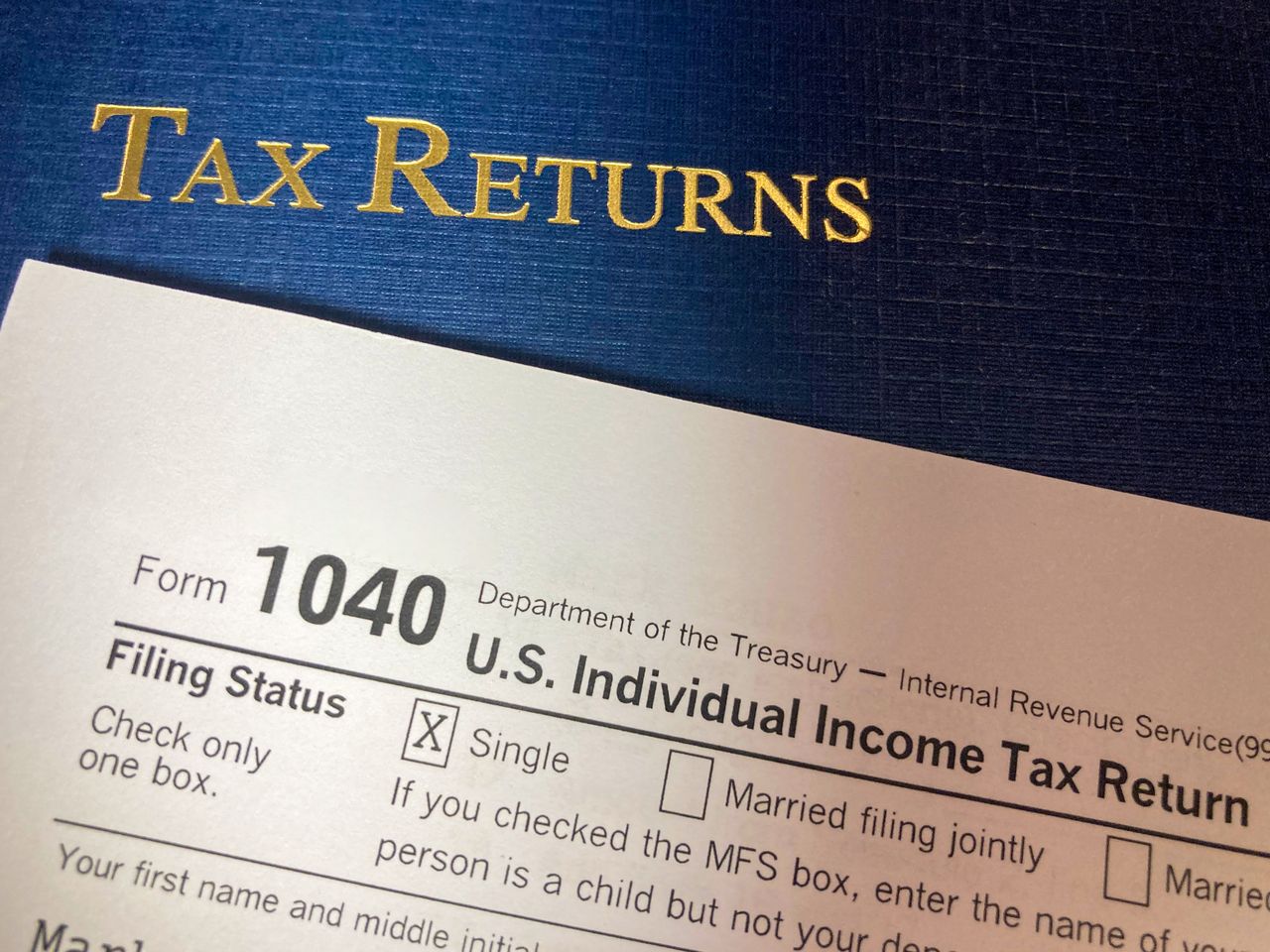 Preparing a tax return online with W-2 and 1040 forms on a desk